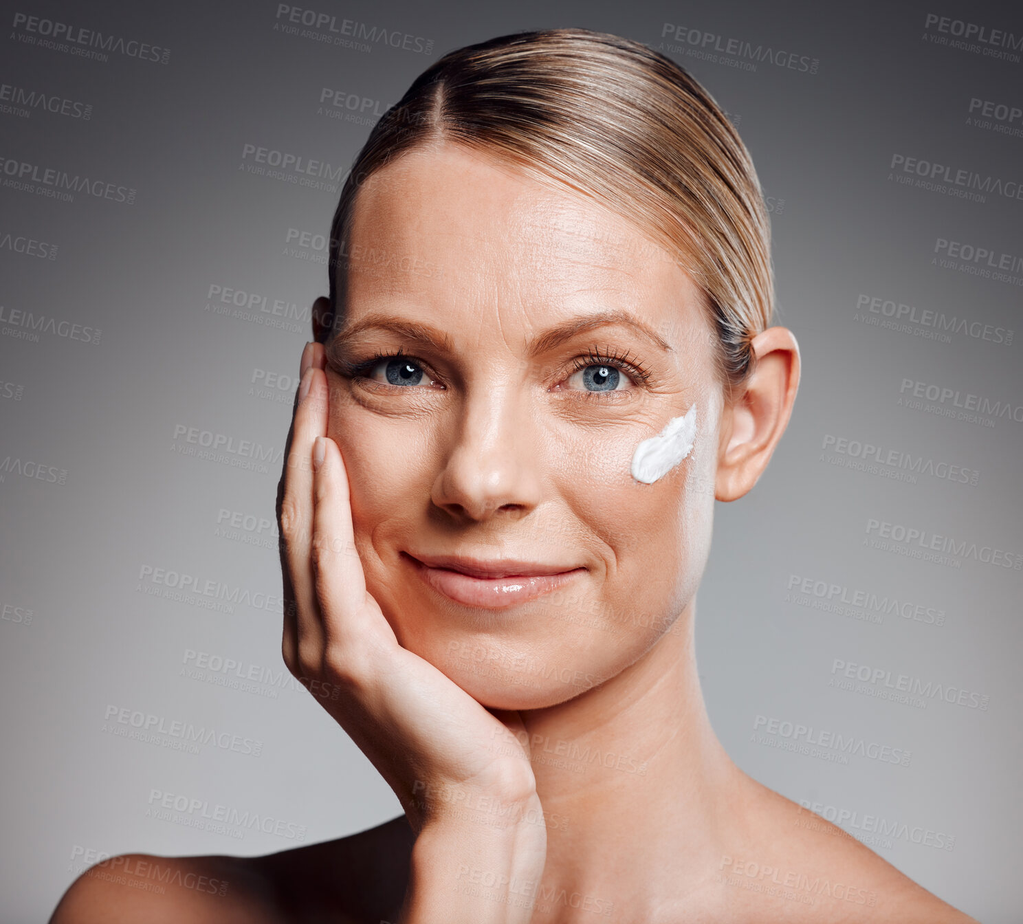 Buy stock photo Portrait, happy woman and skincare cream for beauty, moisturizer and collagen. Lotion, mature model and apply cosmetics on face for dermatology, glow or shine for anti aging on gray studio background