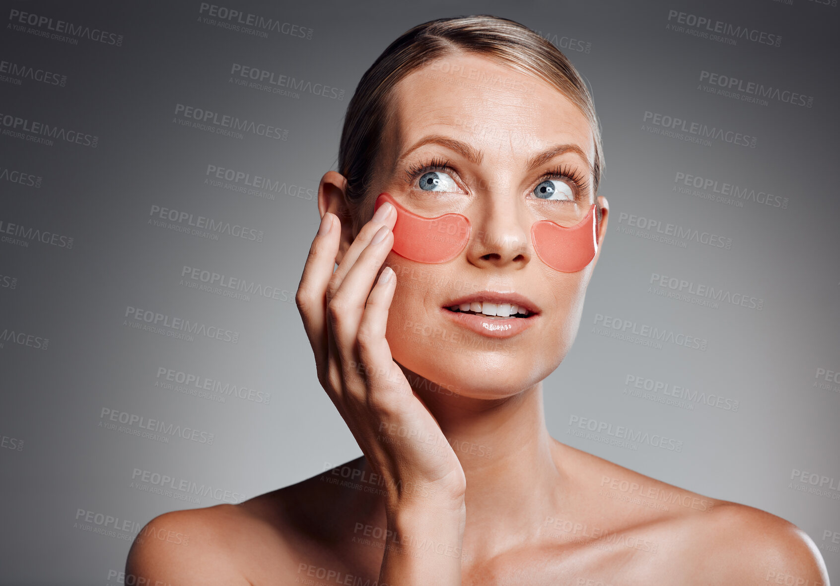 Buy stock photo Mature woman, skincare and eye mask for glow, beauty and collagen treatment. Apply patches, product and model with cosmetics on face for dermatology, anti aging and thinking on gray studio background