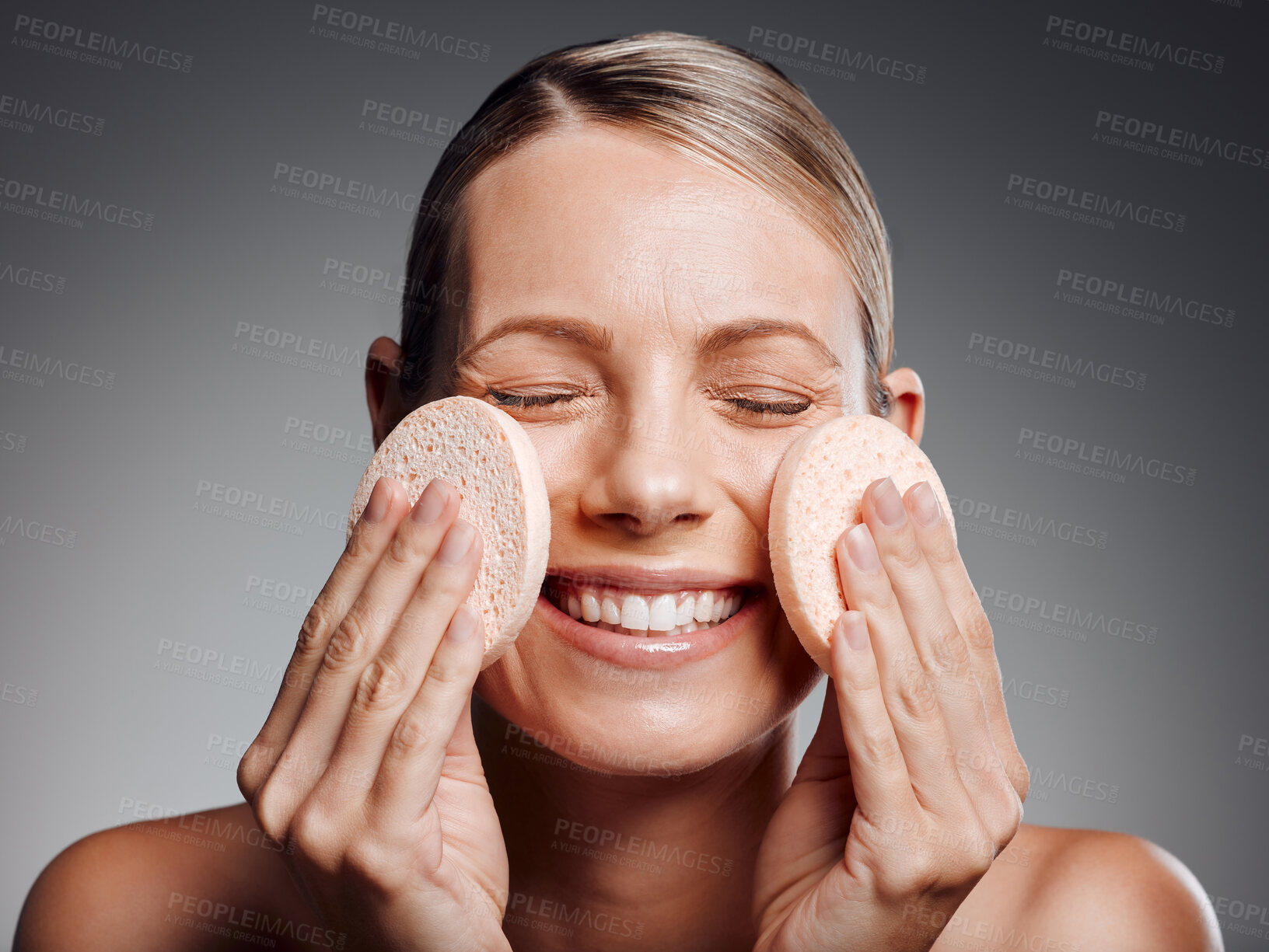 Buy stock photo Beautiful mature woman exfoliating her face in studio against a grey background