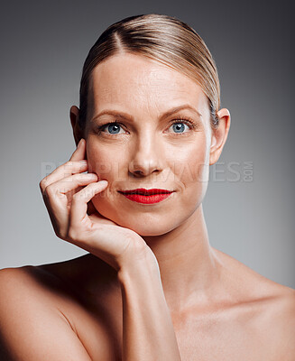 Buy stock photo Portrait, skincare and mature woman in makeup for glow, beauty results or dermatology. Face, touch or confident model with red lipstick for cosmetics, antiaging or aesthetic on gray studio background