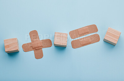 Buy stock photo Plaster, medical and healthcare in studio, wooden blocks and protection for wood care and surgical dressing. Blue background, treatment and prevention of infection, health and bandage in hospital