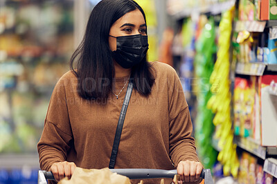 Buy stock photo Grocery shopping, woman and cart at a retail shop, market and store for groceries with mask. Health, virus safety and female person with choice and food browse for purchase in a supermarket at shelf