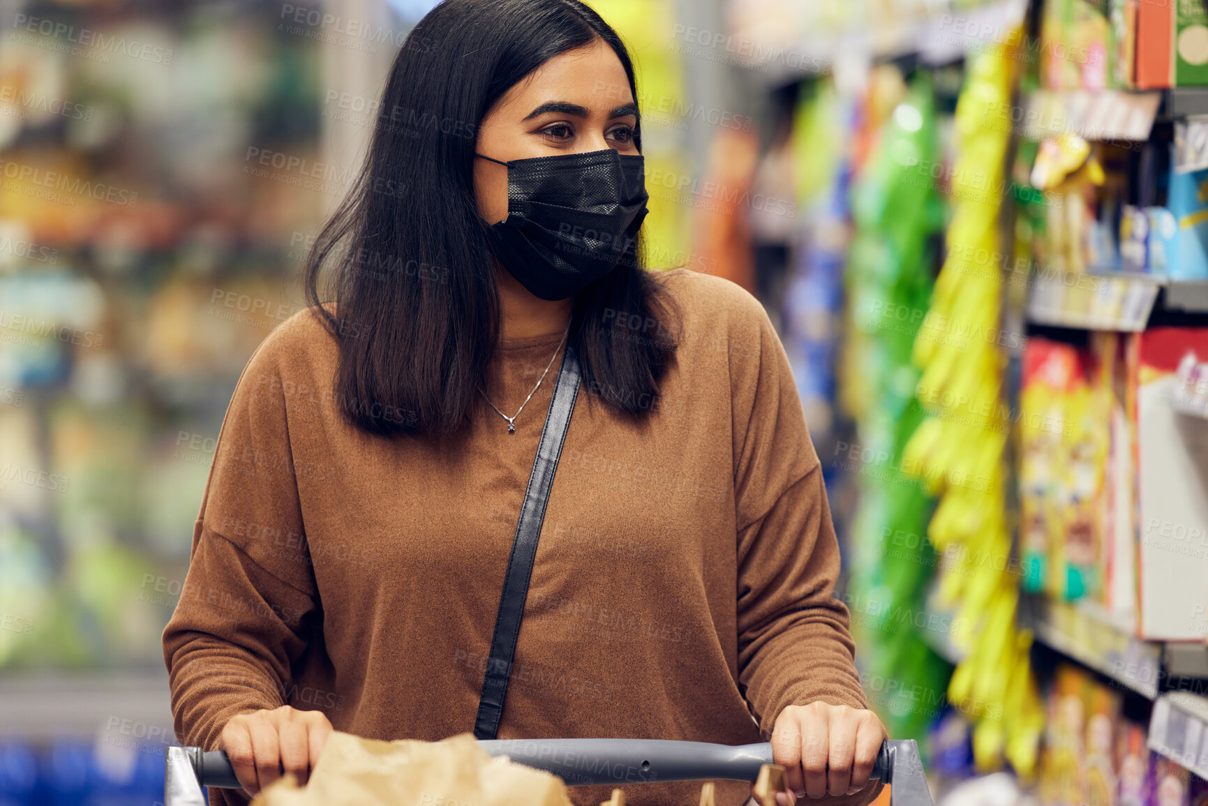 Buy stock photo Grocery shopping, woman and cart at a retail shop, market and store for groceries with mask. Health, virus safety and female person with choice and food browse for purchase in a supermarket at shelf