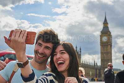 Buy stock photo Travel, phone and couple take a selfie in London to post outdoor city street content on social media. Big ben, freedom and happy woman loves taking pictures with partner on a fun holiday adventure