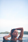 Sexy young woman swimming in the sea. Enjoying a summer vacation and relaxing weekend