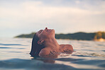 Sexy young woman swimming in the sea. Enjoying a summer vacation and relaxing weekend