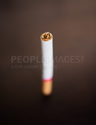 Pics of Closeup of a cigarette isolated on dark background. Stop smoking and quit bad habits like tobacco. Addiction is unhealthy and causes cancer. The tobacco industry has a dark side., stock photo, images and stock photography PeopleImages.com. Picture
