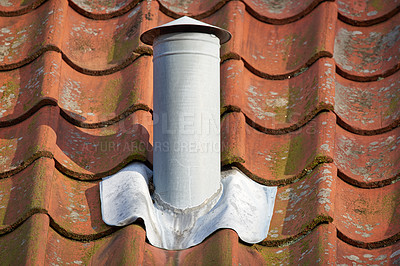 Buy stock photo Closeup shot of a white steel chimney on an old brown tile roof outside. Stay warm this winter with a fireplace. Light a fire and get rid of the smoke quickly and conveniently. Every home needs one