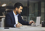 Stressed businessman using a laptop, trading on the stock market in a financial crisis. Trader working online with a computer in a bear market. Market crash and economy depression or failure