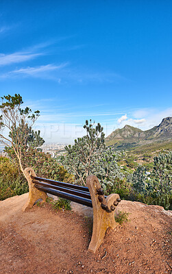 Buy stock photo A wooden bench in an open field outside with a scenic natural mountain and blue sky in the background on a sunny day . Find a quiet place to enjoy the beauty of nature. Nature can be a peaceful and tranquil place when you need to be alone in the outdoors