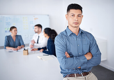 Buy stock photo Portrait of confident mixed race businessman leaning on desk in a boardroom with arms folded. Diverse group of businesspeople in meeting and working behind hispanic manager. Serious professional