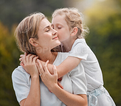 Buy stock photo Nature, hugging and child kissing her mother in an outdoor garden for bonding together. Happy, smile and girl kid embracing her young mom from Canada with love and care in the park or field.