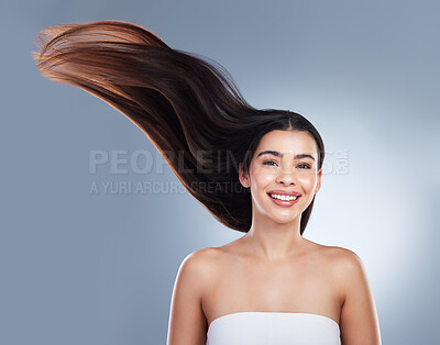 Portrait of woman with shiny smooth long hair. Young brunette woman with beautiful hair. Young girl with long brown hair flying in the wind against a studio background