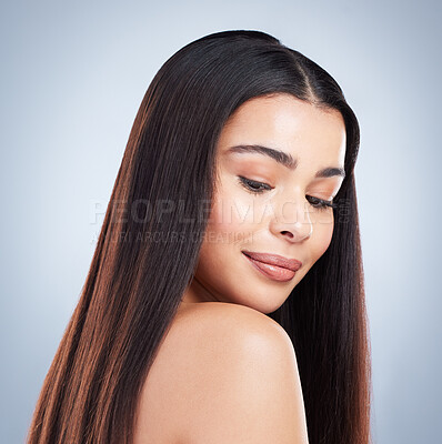Beautiful young woman with shiny brown and straight long hair. Young girl looking down over her shoulder and enjoying healthy hair