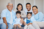 Portrait of extended hispanic family sitting together at home. Happy family with two children, parents and grandparents sitting together and bonding on a couch