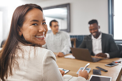 Buy stock photo Portrait of a young asian business woman smiling while sitting in the boardroom during a meeting with her colleagues. A team talking strategy and planning for success. There's a new girl boss in town
