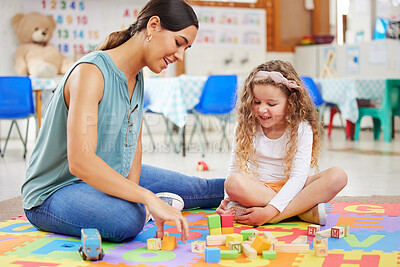 Young mother and daughter playing with colourful,bright toys at preschool. A smiling teacher teaching a student using toy blocks. Happy caucasian child playing with plastic toys at kindergarten