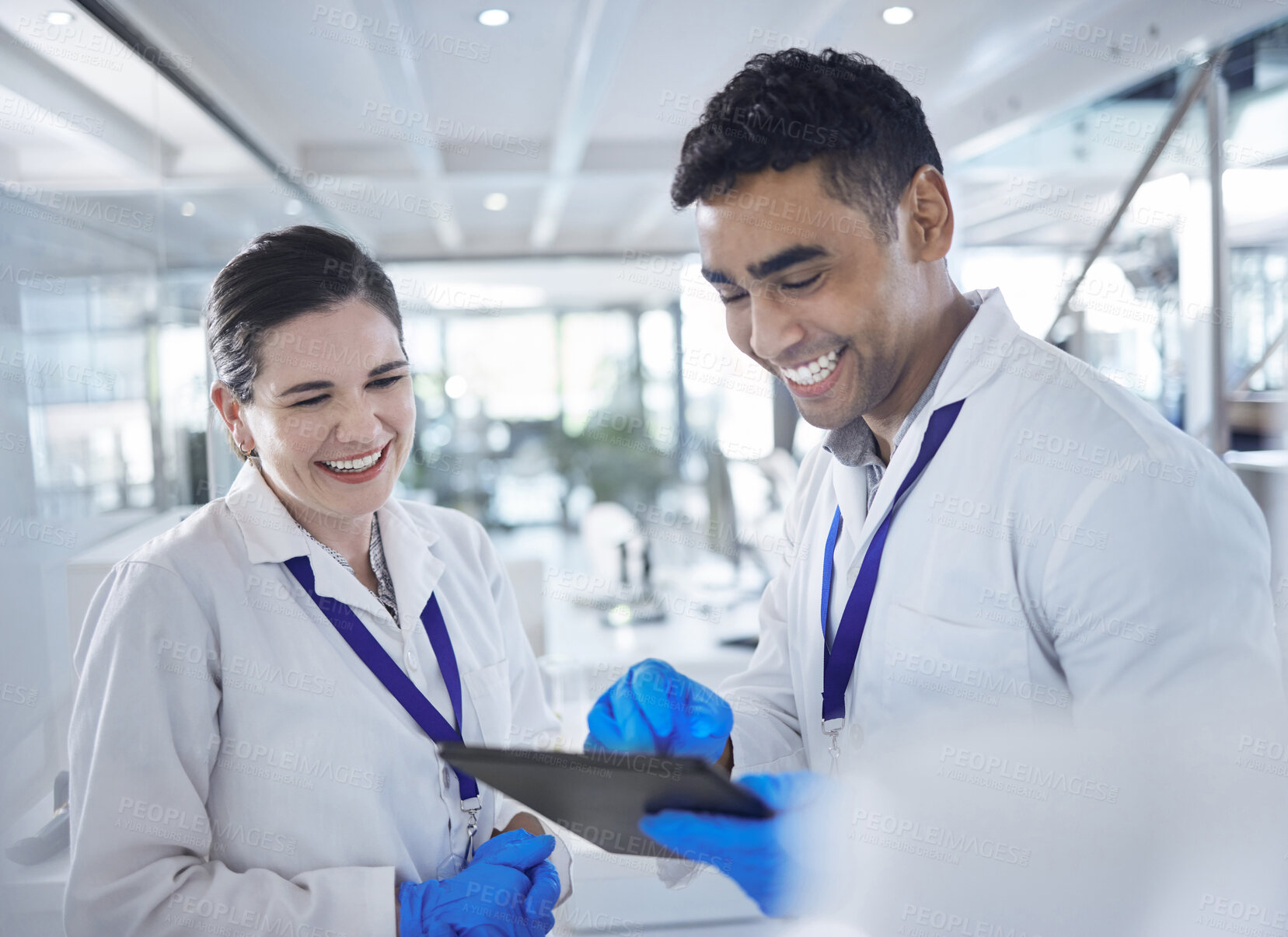 Buy stock photo Tablet, scientist and happy in laboratory for healthcare, gloves and medical research for vaccine cure. Woman, man and diversity by touchscreen and pharmaceutical analysis with science collaboration