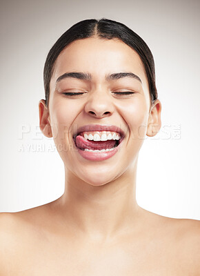 Buy stock photo Young joyful mixed race woman sticking out her tongue and posing against a grey studio background. Confident hispanic female smiling while posing against a background