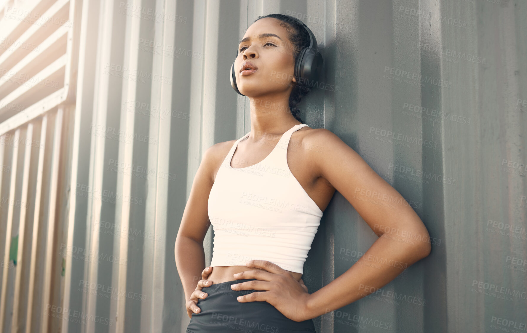 Buy stock photo Fitness break, breathe or girl runner in city listening to music, podcast or radio playlist in sports exercise. Wellness, headphones or tired woman athlete resting after training or workout outdoors