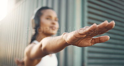 Closeup of one fit hispanic woman stretching arms in warrior pose for warmup to prevent injury while exercising in an urban setting outdoors. Hands of motivated female athlete preparing body and mind for training workout or run