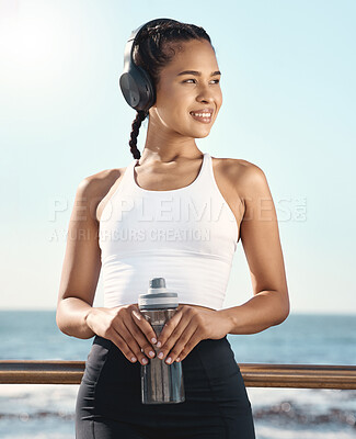 Buy stock photo Thinking, headphones and woman fitness at beach, mental health music and audio streaming for wellness and health. Water bottle, gear and athlete, runner or sports person by sea listening or streaming