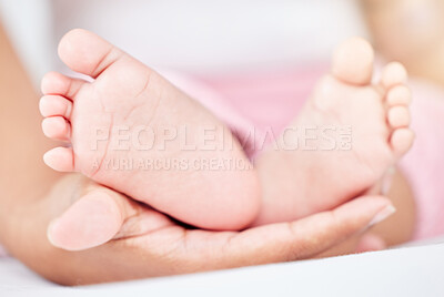 Buy stock photo Family, care and the feet of a baby in the hands of a parent closeup in the bedroom of their home together. Kids, love or wellness and an infant child on a bed in an apartment with an adult person