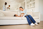 Young happy and cheerful african american mother playing and bonding with her daughter on the couch in the lounge at home. Black woman playing with her cute little girl on the weekend