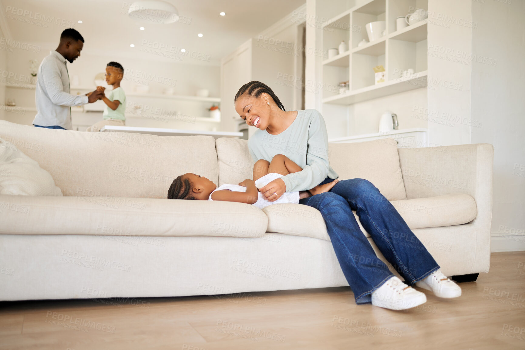 Buy stock photo Black family, smile and a mother tickling her daughter on a sofa in the living room of their home together. Children, love or smile and a young woman playing with her girl child in their apartment