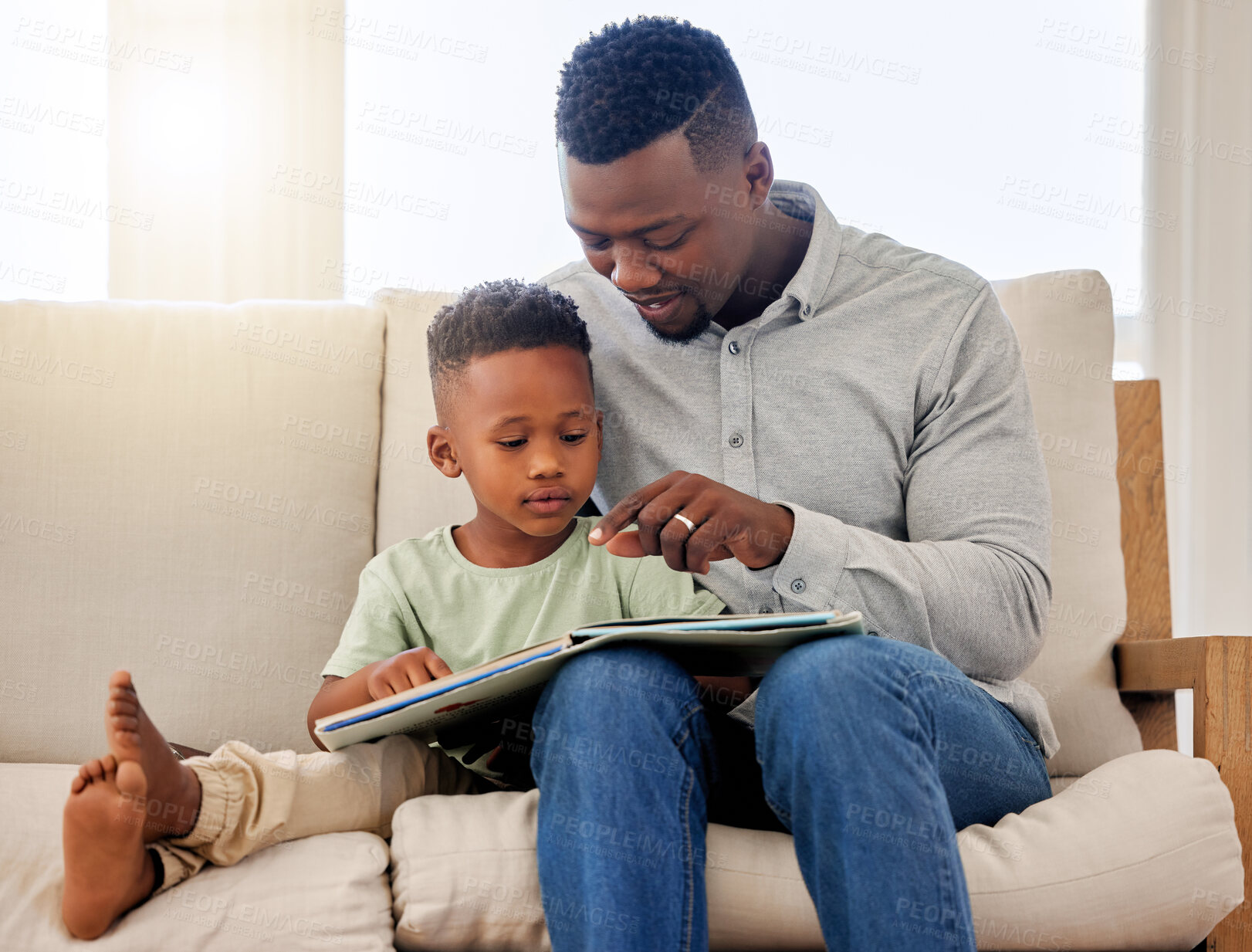 Buy stock photo African, child and father reading a book in home on sofa with development of education, learning and knowledge. Happy dad, teaching and show kid a story in books and relax in living room on couch