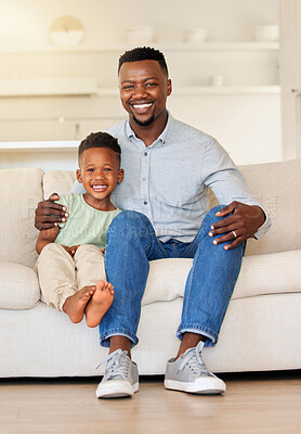 Buy stock photo Happy, smile and portrait of child with father on sofa in the living room of modern house for bonding. Care, love and young African boy kid sitting with his dad on couch of lounge at home together.