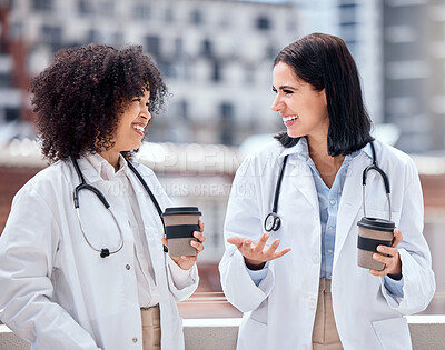 Buy stock photo Conversation, coffee and young women doctors talking on medical diagnosis on hospital rooftop. Smile, discussion and female healthcare workers speaking and drinking cappuccino on clinic balcony.