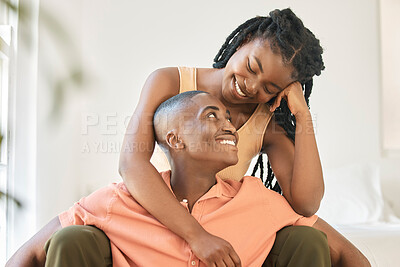 Buy stock photo Young happy carefree and cheerful african american couple bonding and enjoying relaxing time together at home. Loving black female smiling while hugging and looking at her boyfriend sitting together