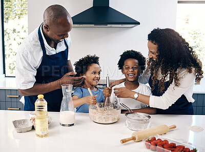 Buy stock photo Happy african american family baking in their kitchen together. Cheerful mother and father playing with their sons while cooking. Brothers mixing a bowl of batter, having fun with their parents