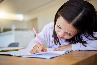 Buy stock photo Little schoolgirl doing homework at table. Smart elementary aged child writing in notebook