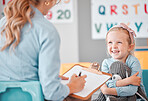 Smiling little girl with social worker in a clinic. Child psychologist writing on a clipboard during consult with adorable kid. Caucasian woman signing adoption paperwork while girl holds a teddy bear