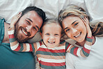 Happy smiling caucasian family of three looking cosy together in bed at home. Loving parents with their little daughter. Adorable young girl hugging her mom and dad's face and taking a selfie 
