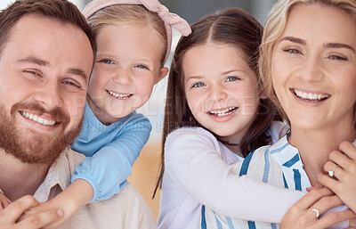 Buy stock photo Happy caucasian family of four smiling while relaxing together at home. Carefree loving parents bonding with two cute little daughters. Adorable young playful girls hugging mom and dad