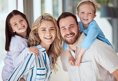 Buy stock photo Happy caucasian family of four smiling while relaxing together at home. Carefree loving parents bonding with their cute little daughters. Sisters playing with their parents on the weekend