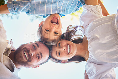 Buy stock photo Family of three from below. Portrait of a young couple and their cute son posing outside with the clear blue sky in the background. Happy boy smiling with his mother and father outdoors during summer