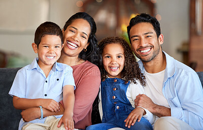 Buy stock photo Portrait of a smiling couple with little kids at home. Mixed race mother and father bonding with their son and daughter on a weekend inside. Hispanic boy and girl enjoying free time with their parents