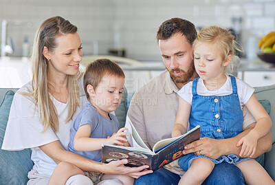 Young caucasian family reading a book together on the couch at home. Mother and father teaching their little son and daughter how to read. Siblings learning their alphabet with their parents