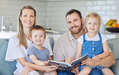 Portrait of young parents with children reading a book, caucasian family of four smiling and enjoying a story. Cheerful couple teaching their two children how to read while sitting on a sofa