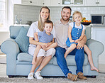 Happy and cheerful caucasian family with two kids smiling while sitting on couch together at home. Loving parents bonding with their adorable little son and daughter