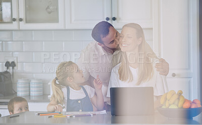 Buy stock photo husband kissing wife on the cheek. Family relaxing in the kitchen. Woman working from home on laptop. Mother teleworking with children.  Happy family at home together. 