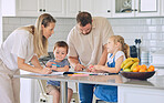 Boy and girl learning and studying in homeschool with mom and dad. Caucasian couple helping their two little preschool kids with colouring, homework and assignments. Parents teaching children at home