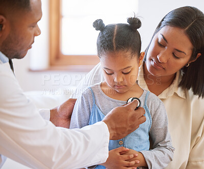 Sad little girl at doctor\'s office. Sick girl sitting with mother while male paediatrician listen to chest heartbeat. Male doctor examining child with stethoscope. Mom holding kid during doctor visit