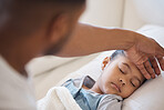 Sick mixed race girl lying asleep in bed at home. Worried father using his hand to feel the high body temperature on his little daughter's forehead for symptoms of fever, flu or covid