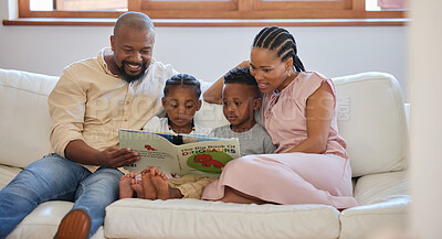 Always makeA young african american family sitting on the sofa together and smiling while reading a story book at hometime for family