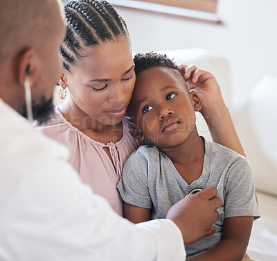 African american male paediatrician examining sick boy with stethoscope during visit with mom. Doctor checking heart lungs during checkup in hospital. Sick or sad boy receiving medical care